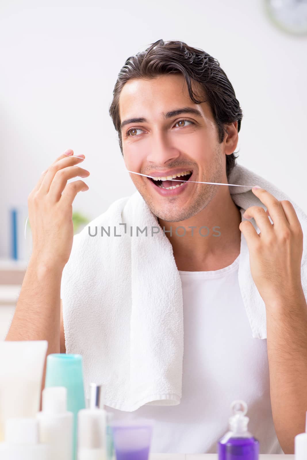 Young handsome man in the bathroom in hygiene concept 