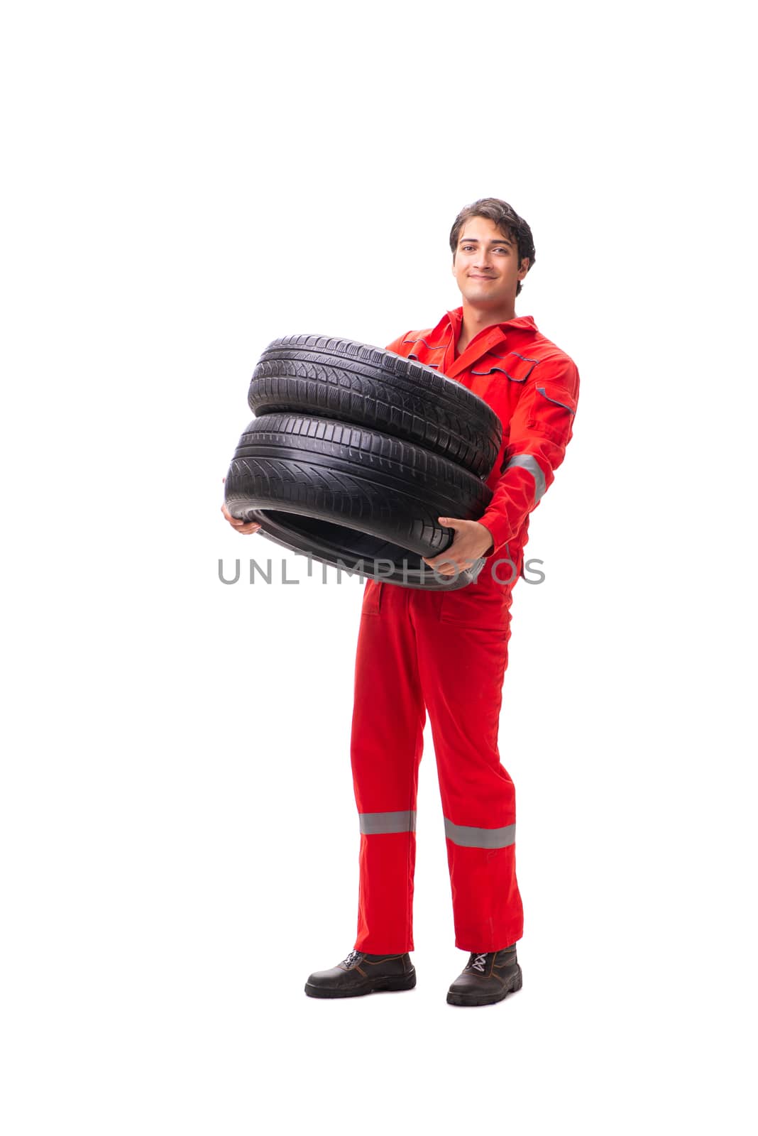 Young garage worker with tyre isolated on white by Elnur