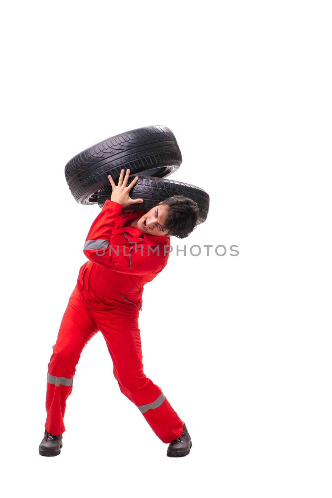 Young garage worker with tyre isolated on white by Elnur