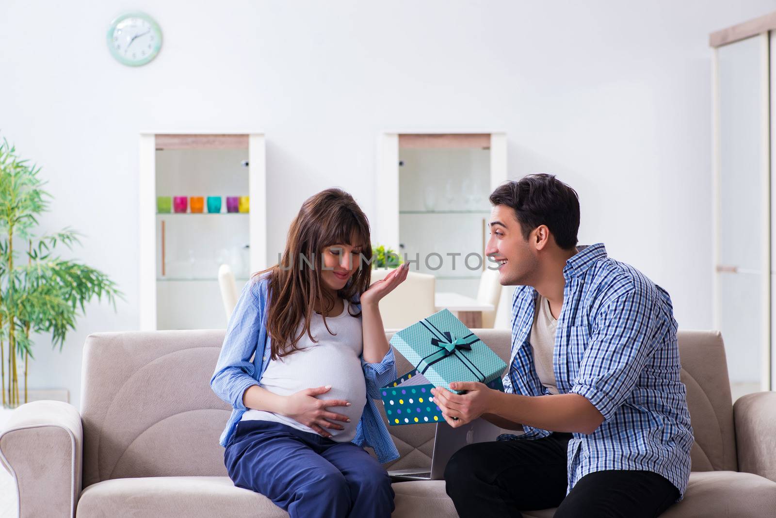 Happy family celebrating pregnancy at home by Elnur