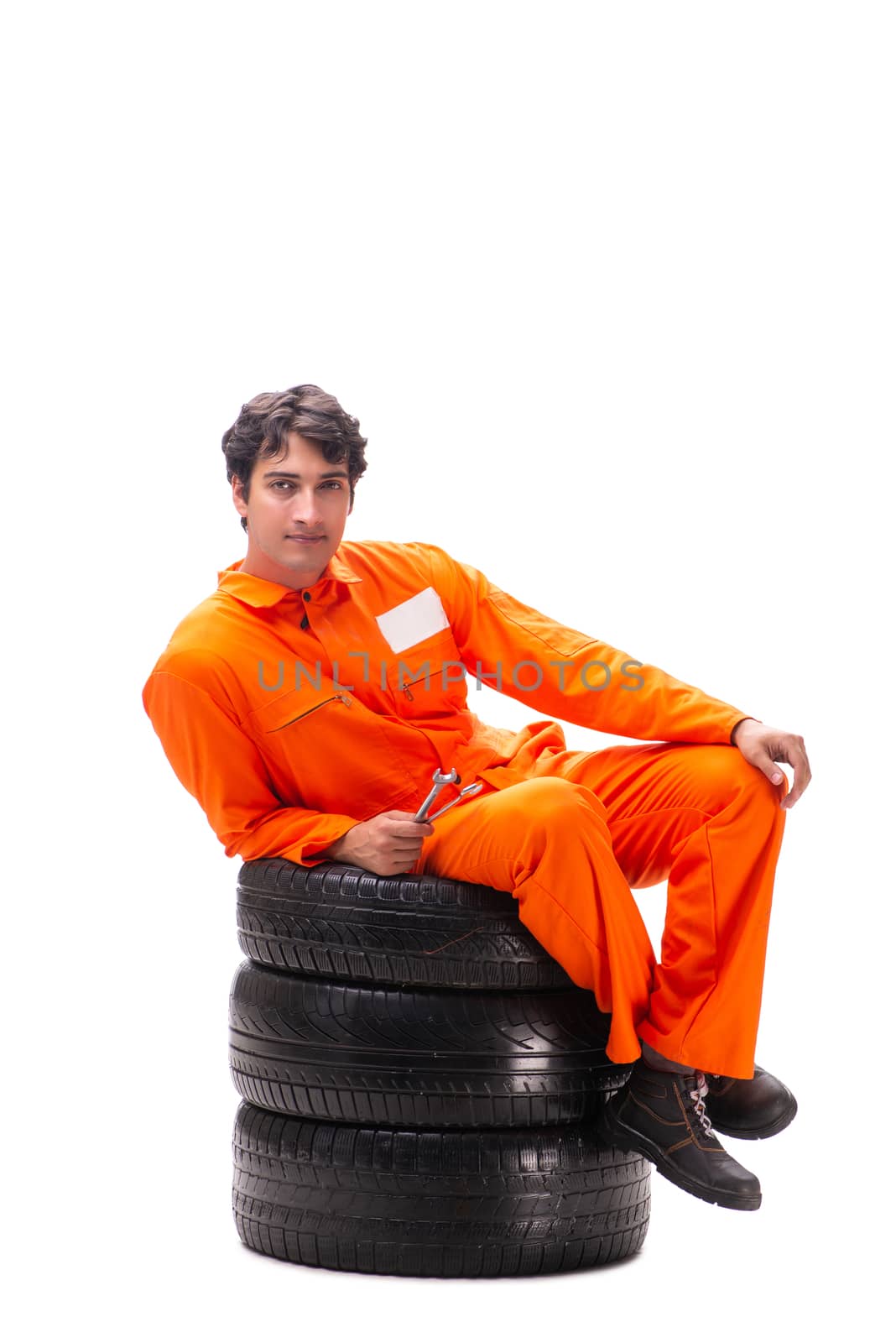 Young garage worker with tyre isolated on white