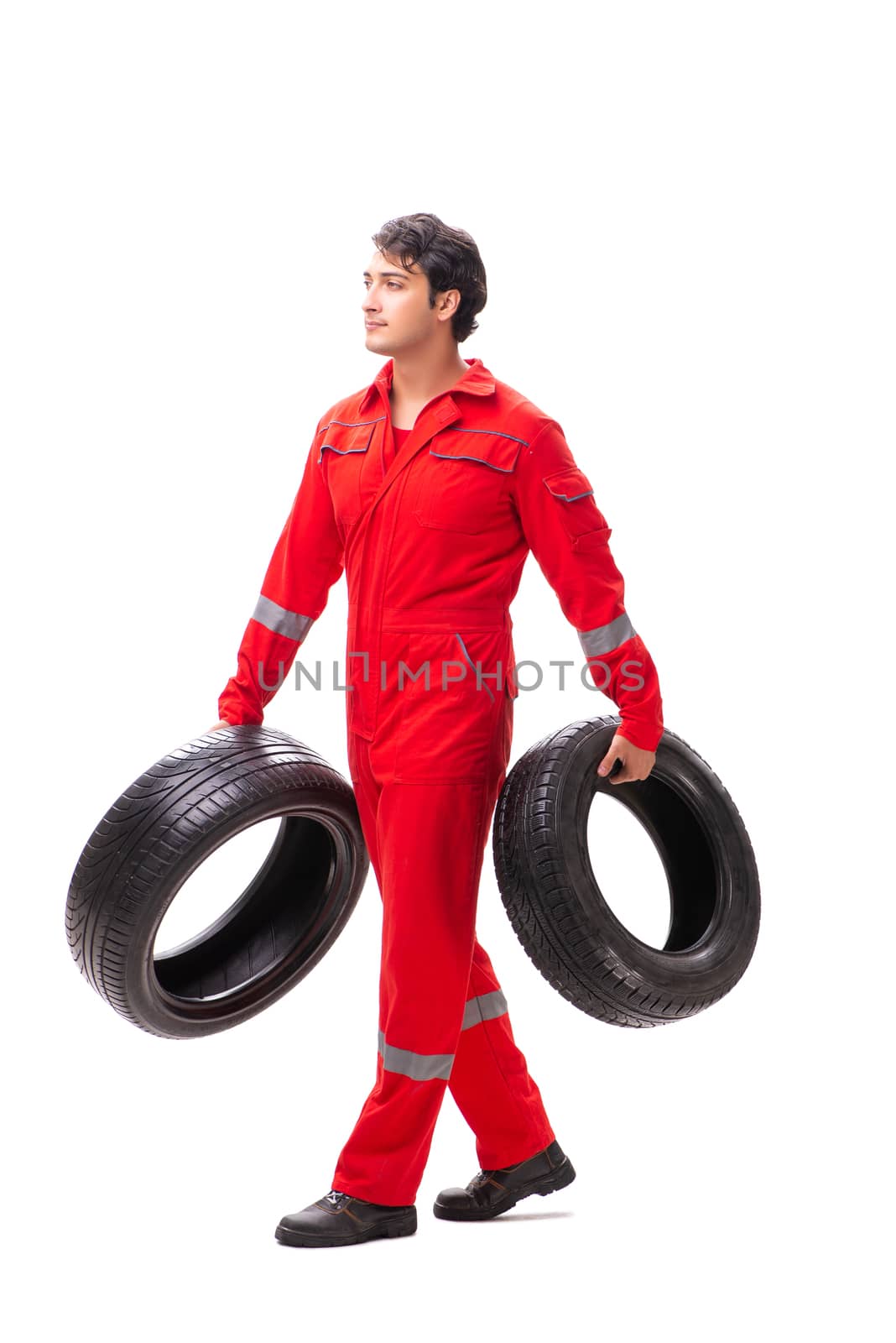 Young garage worker with tyre isolated on white