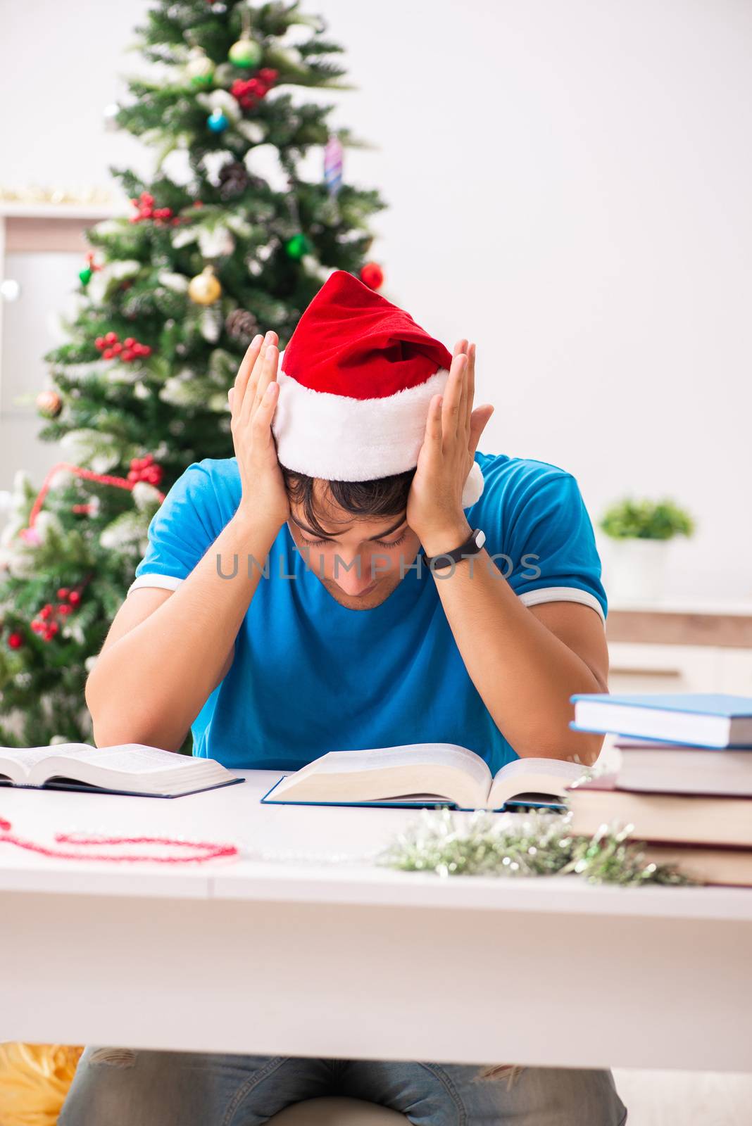 Young student with book at Christmas eve  by Elnur