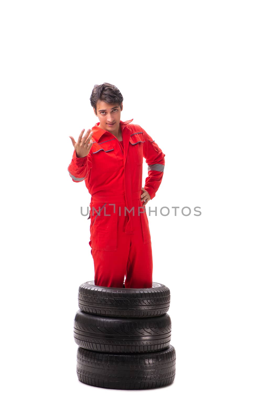 Young garage worker with tyre isolated on white