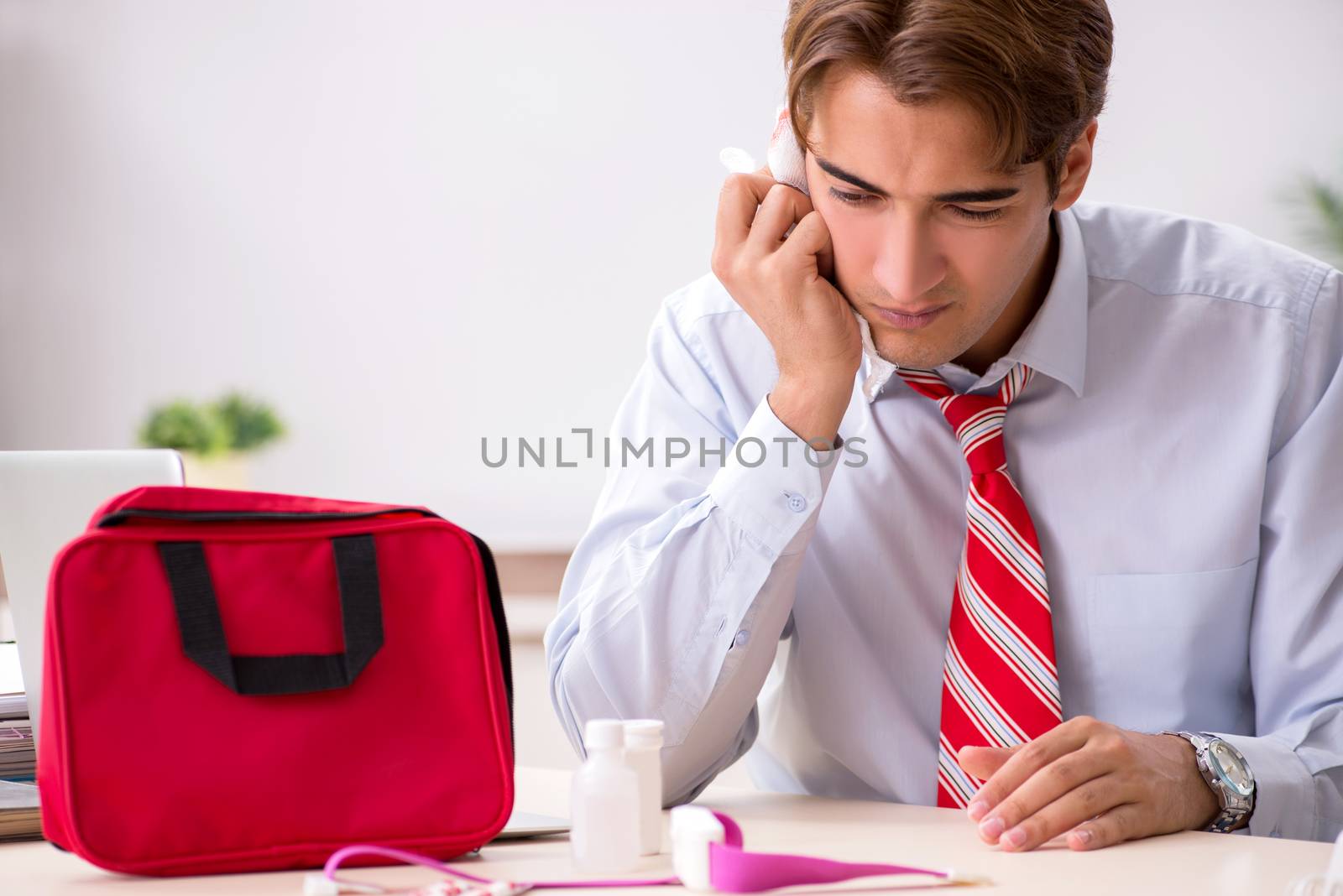 Man with first aid kit in the office