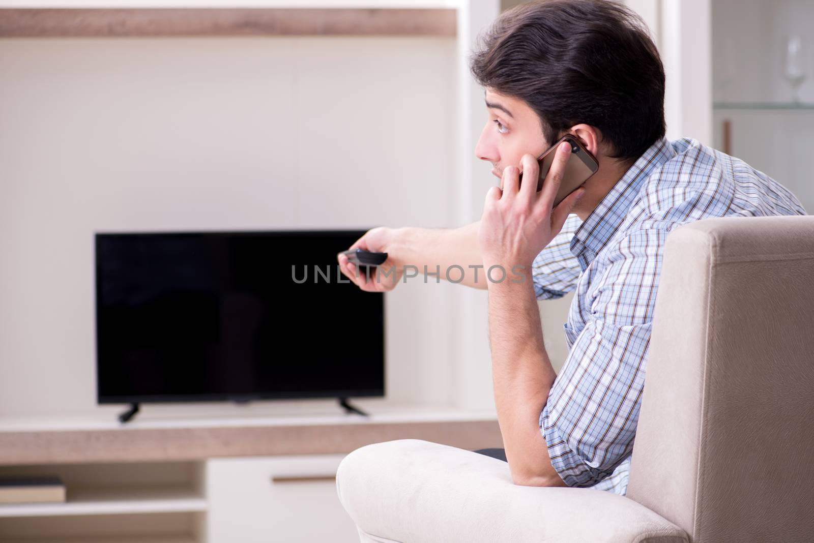 Young man watching tv at home
