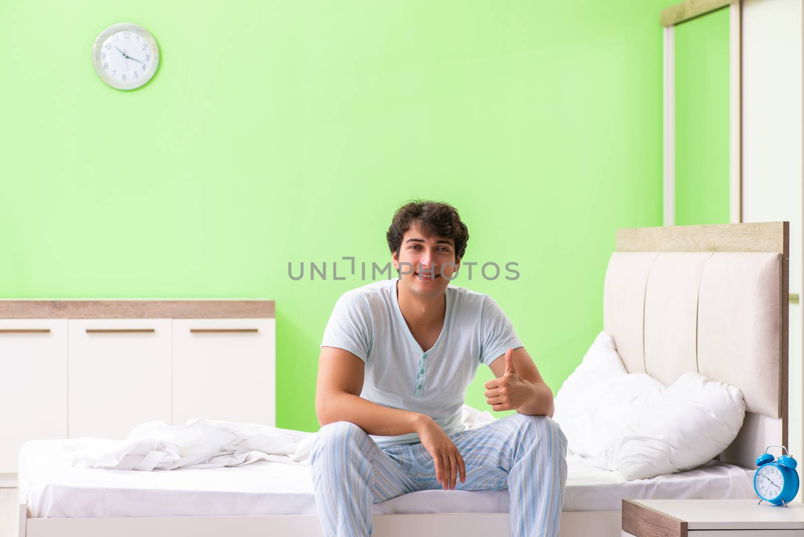Young man having trouble waking up in early morning