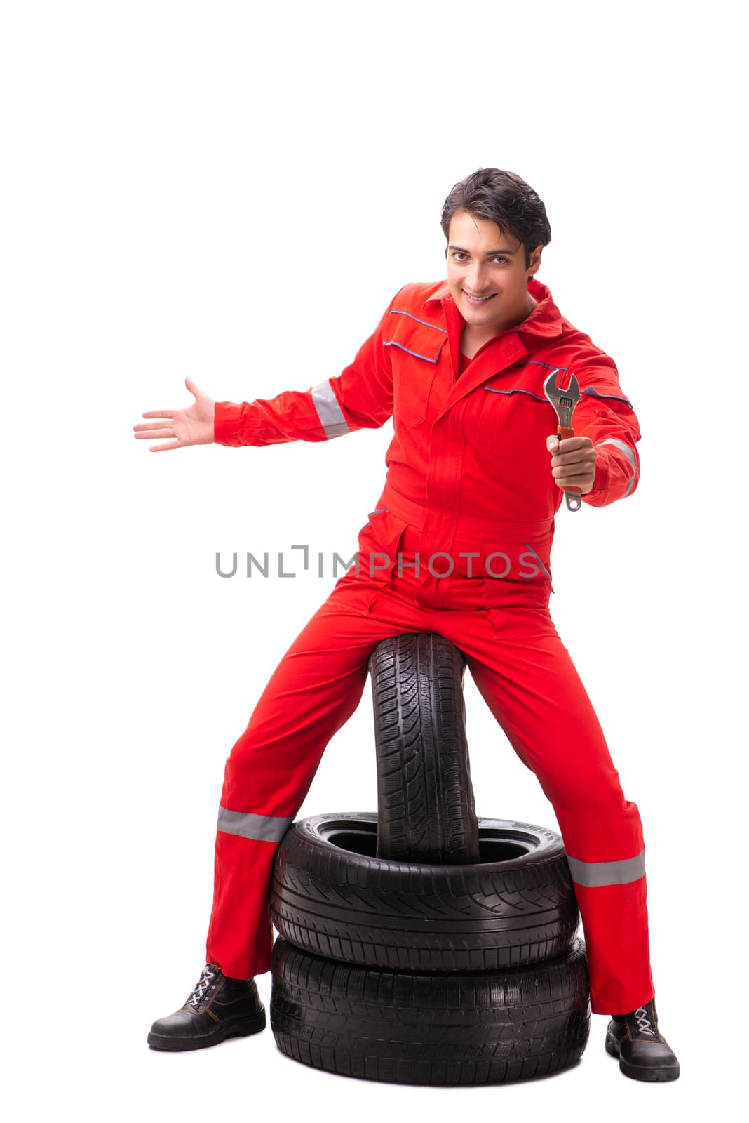 Young garage worker with tyre isolated on white