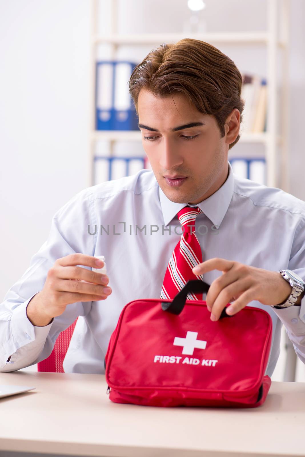 Man with first aid kit in the office