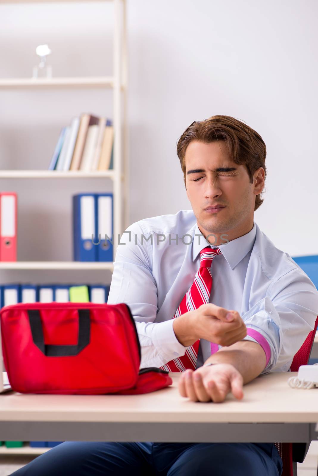 Man with first aid kit in the office