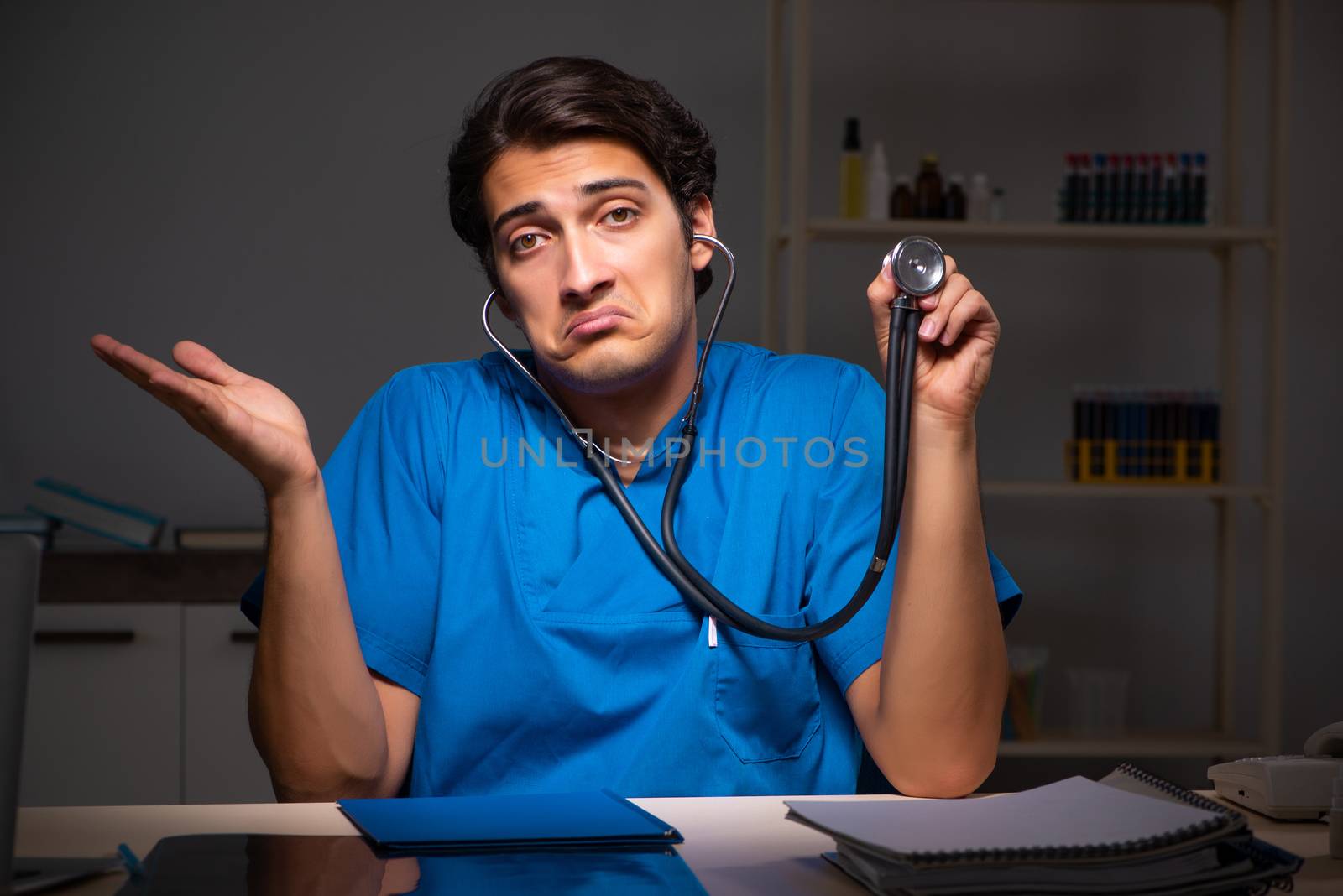 Young handsome doctor working night shift in hospital   