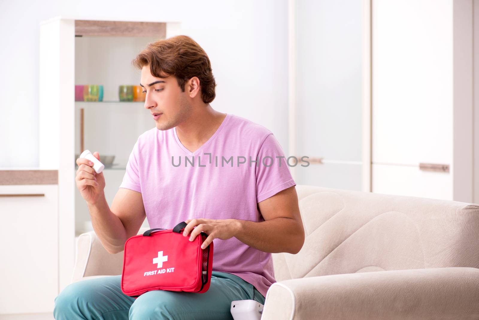 Sick man at home with first aid kit