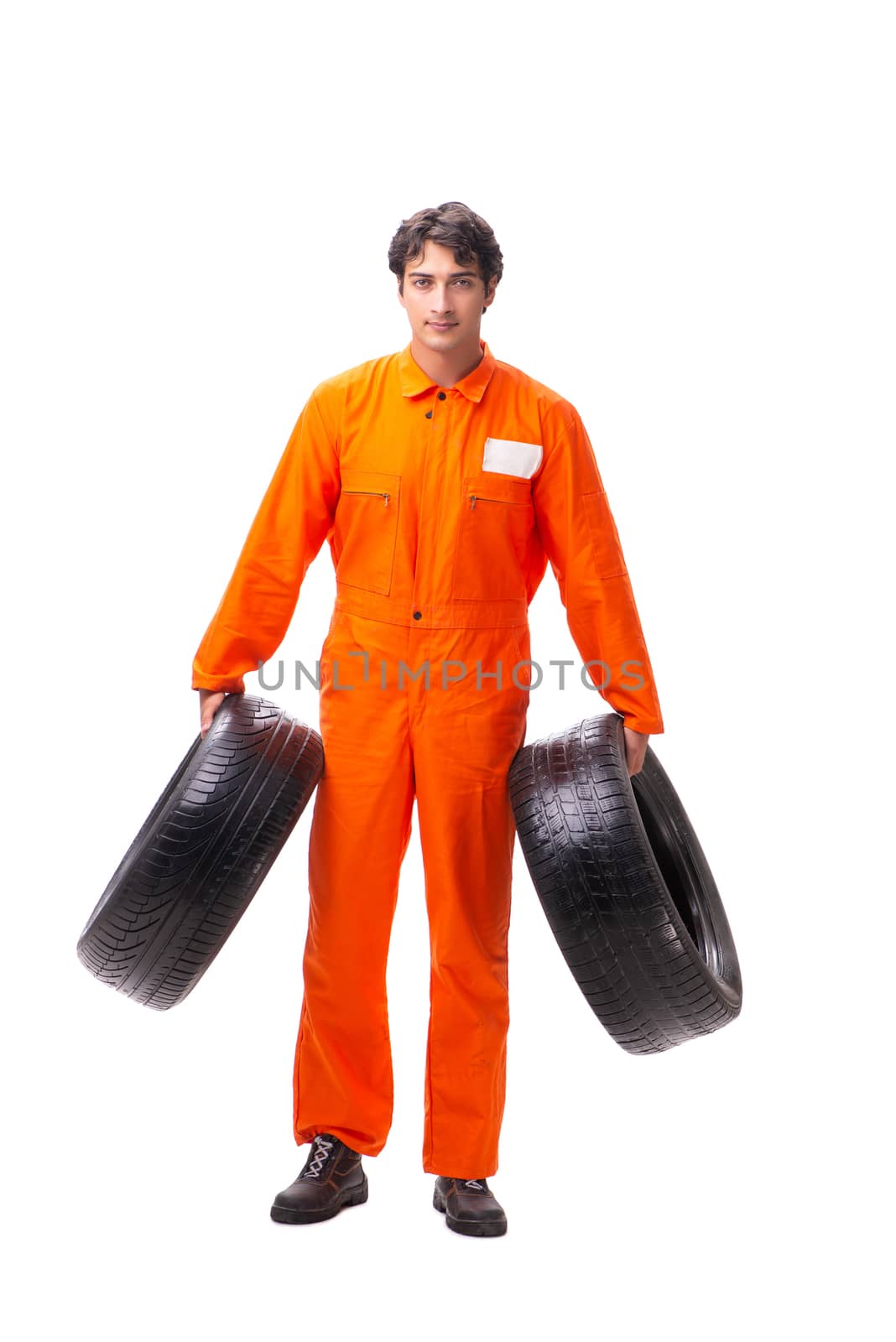 Young garage worker with tyre isolated on white