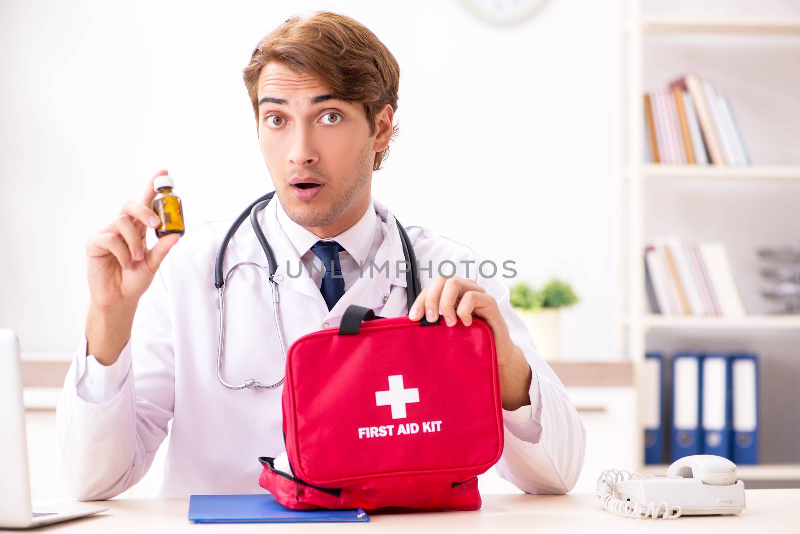 Young doctor with first aid kit in hospital