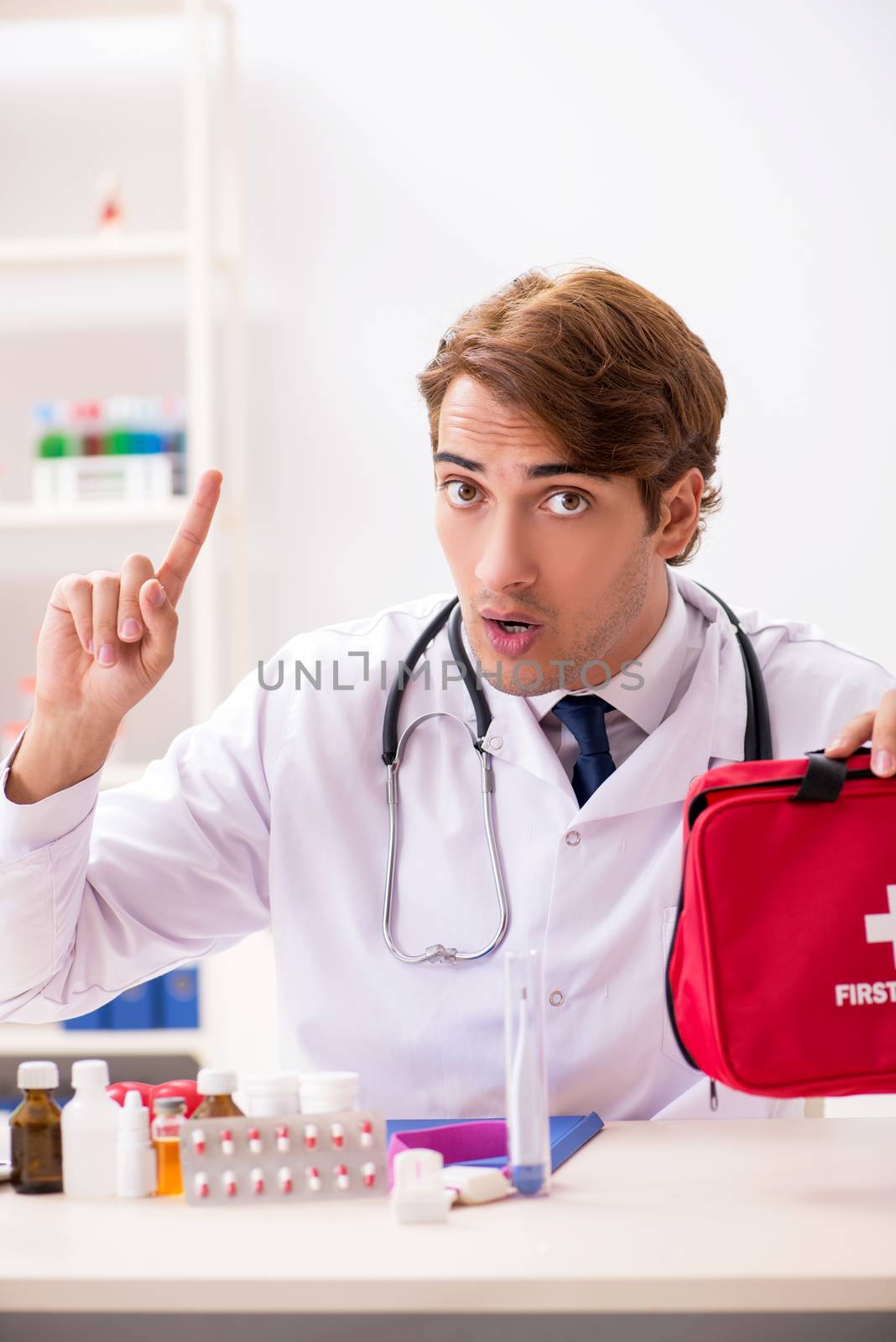 Young doctor with first aid kit in hospital by Elnur