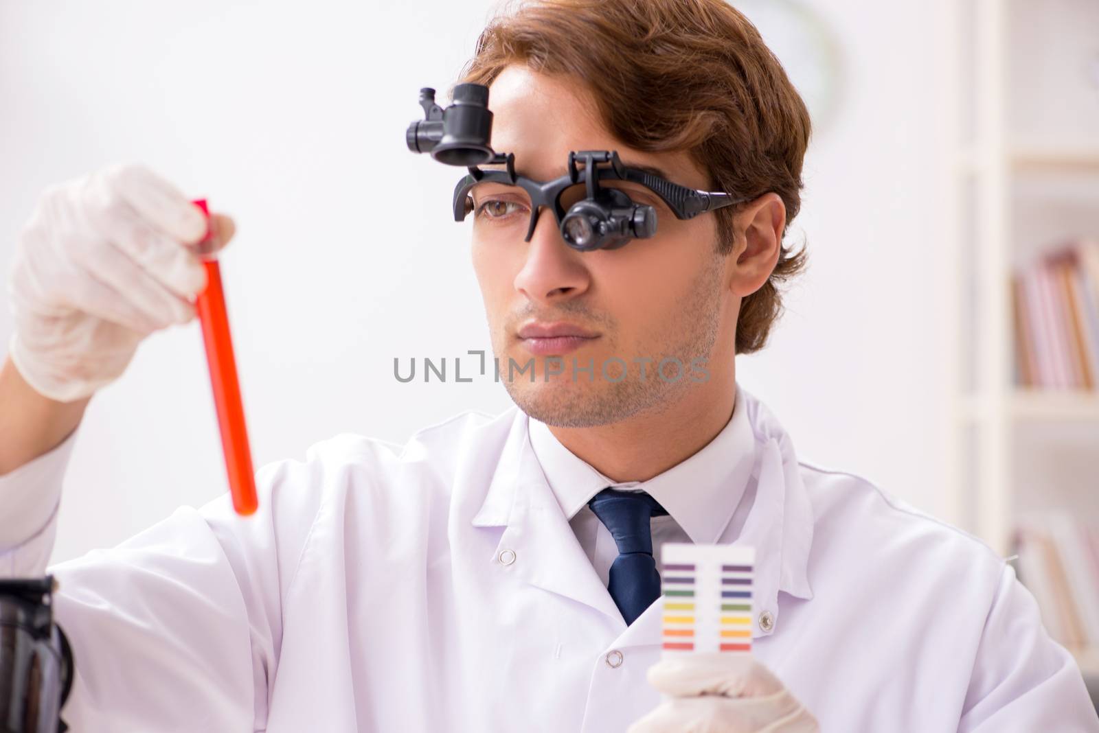 Chemist in the lab checking with ph strips