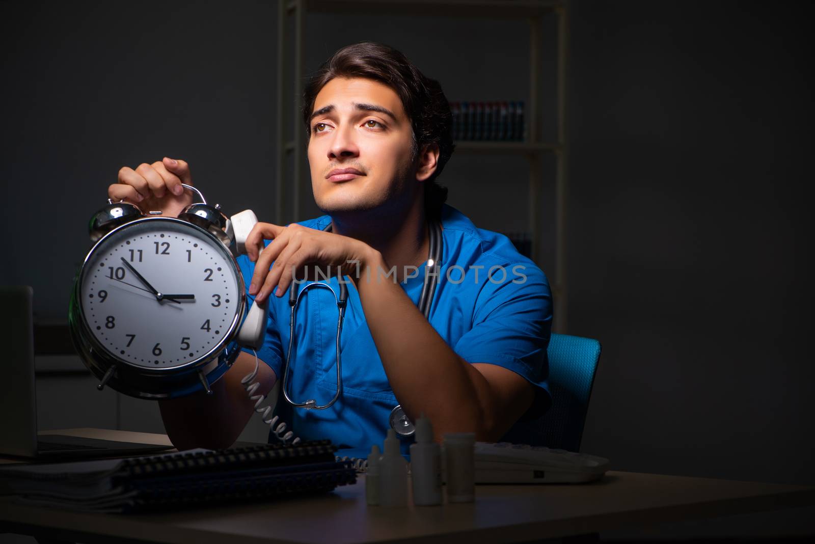 Young handsome doctor working night shift in hospital   