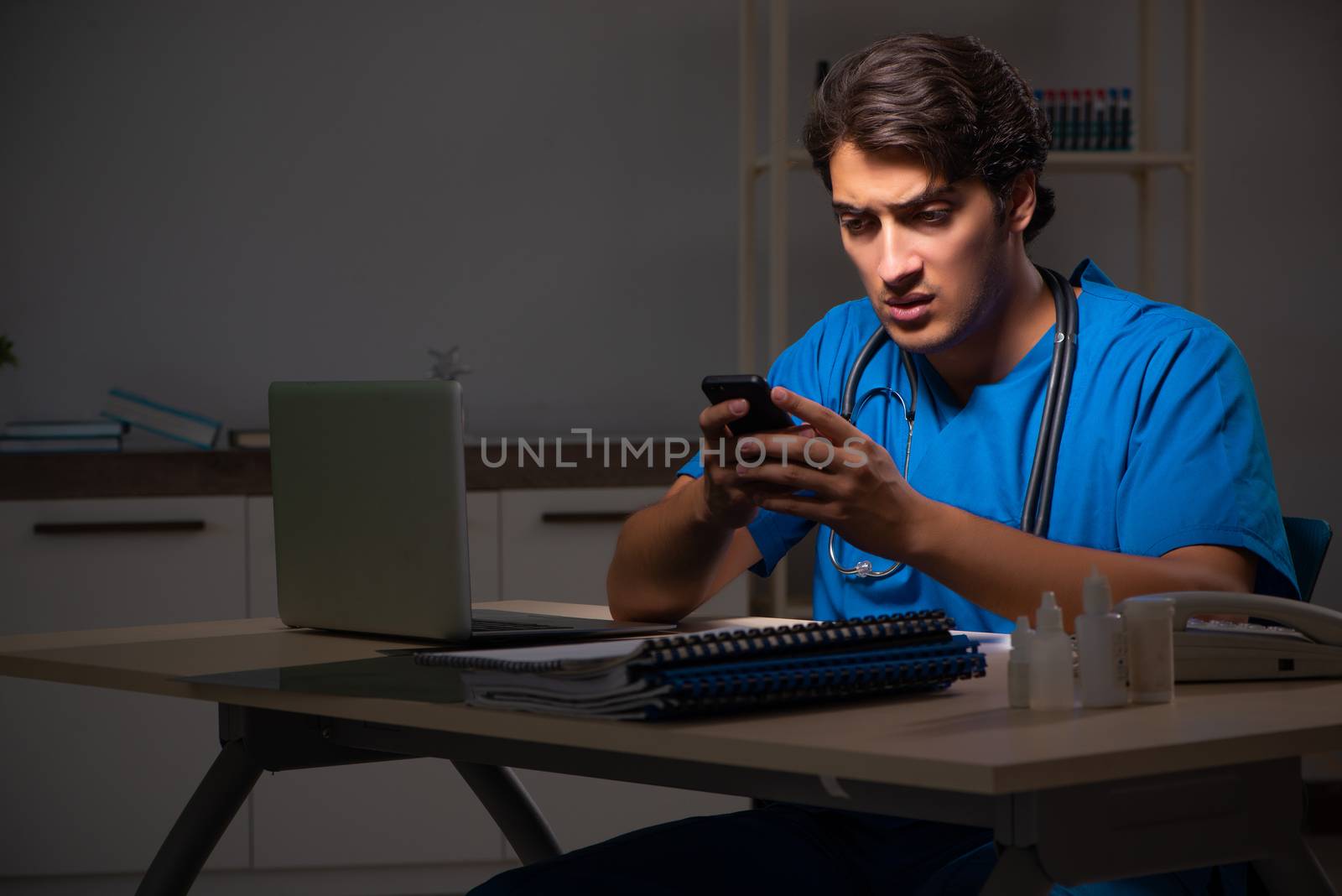 Young handsome doctor working night shift in hospital   