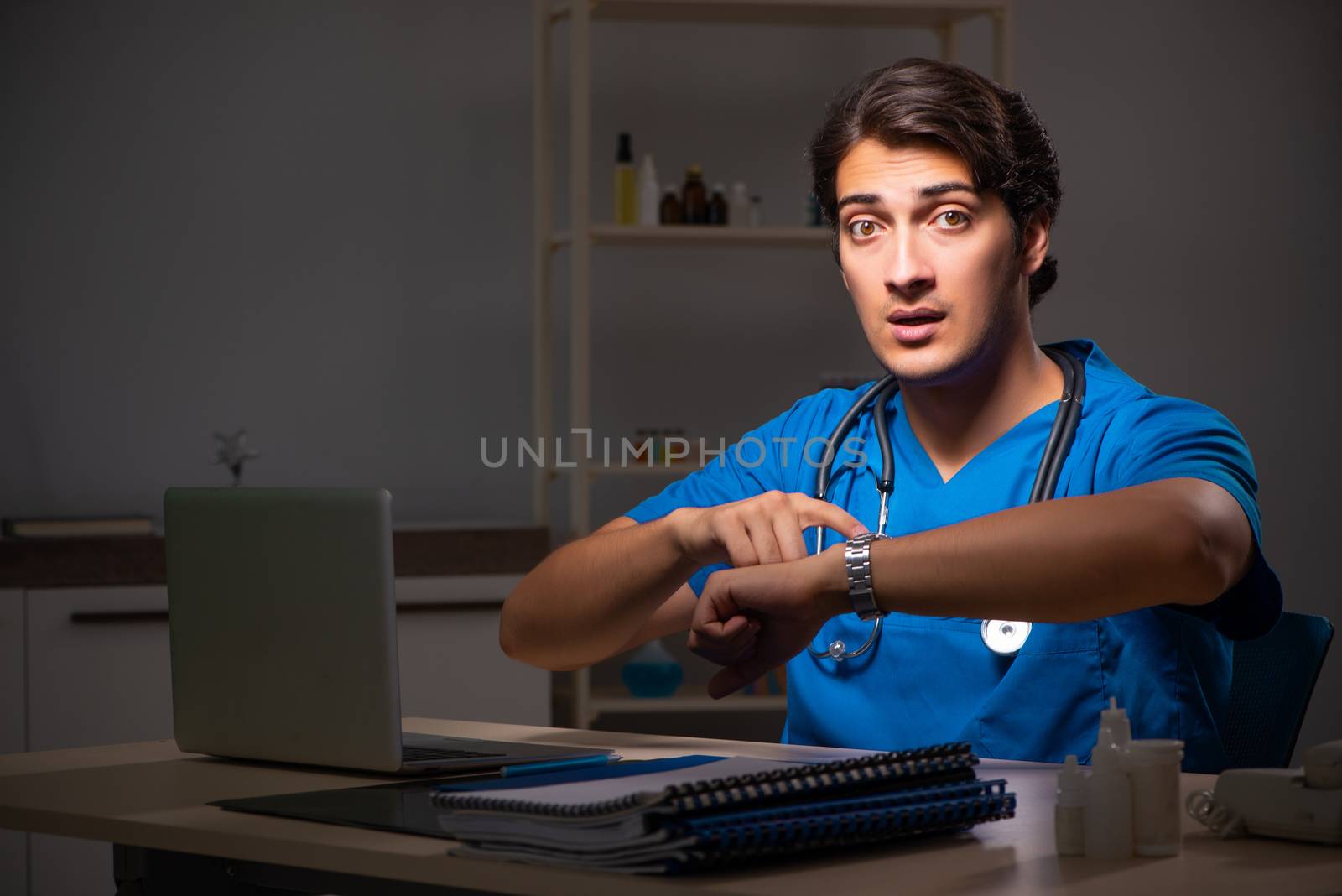 Young handsome doctor working night shift in hospital   