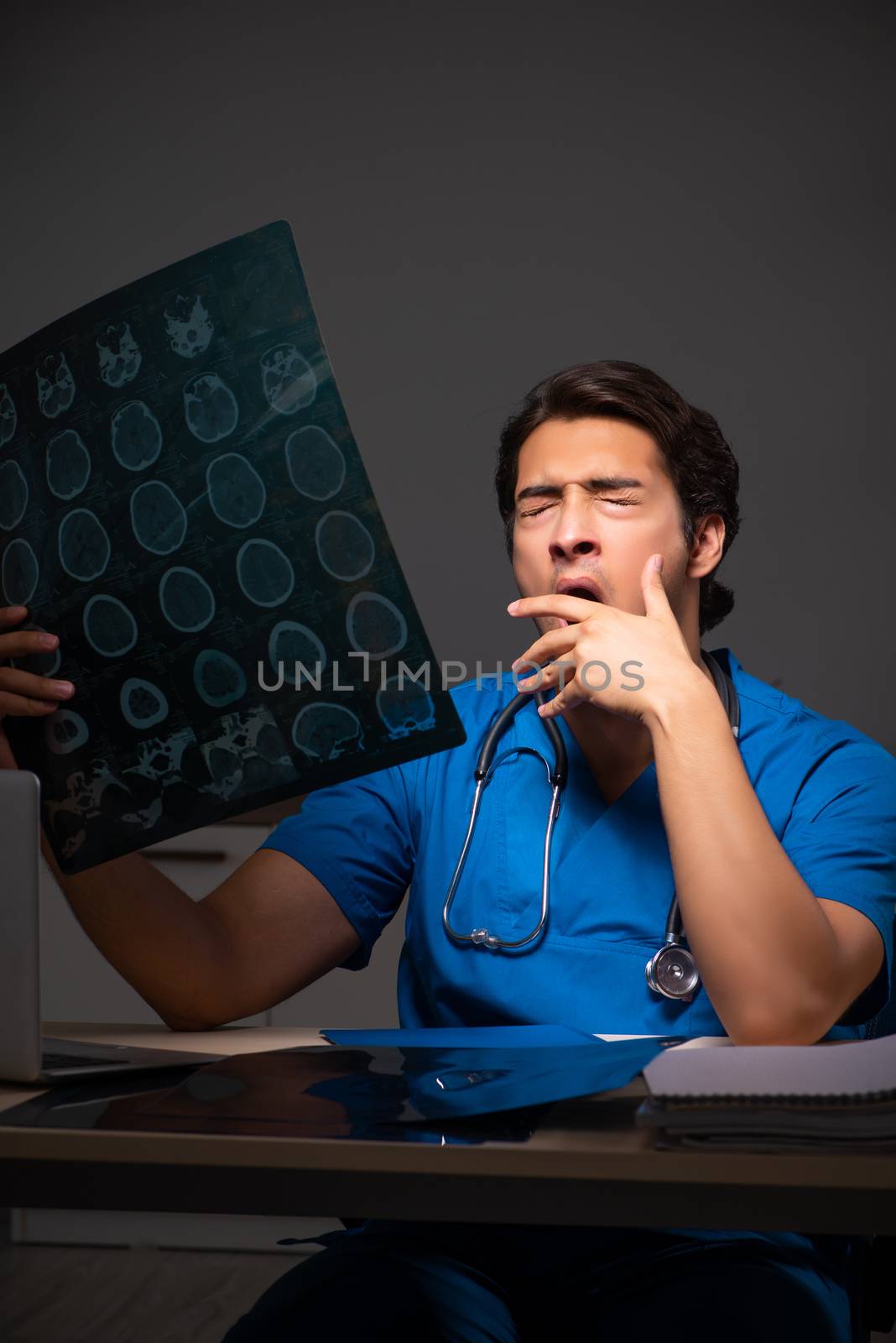 Young handsome doctor working night shift in hospital   