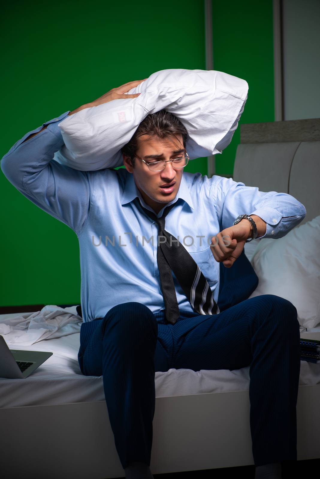 Young businessman under stress in the bedroom at night by Elnur