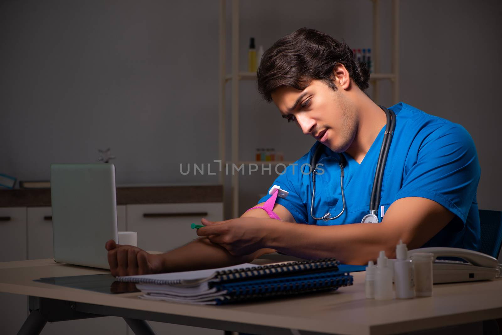 Young handsome doctor working night shift in hospital   
