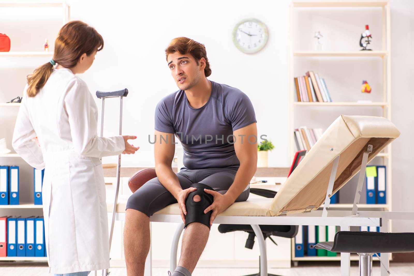 Handsome american footbal player visiting female doctor traumatologist 