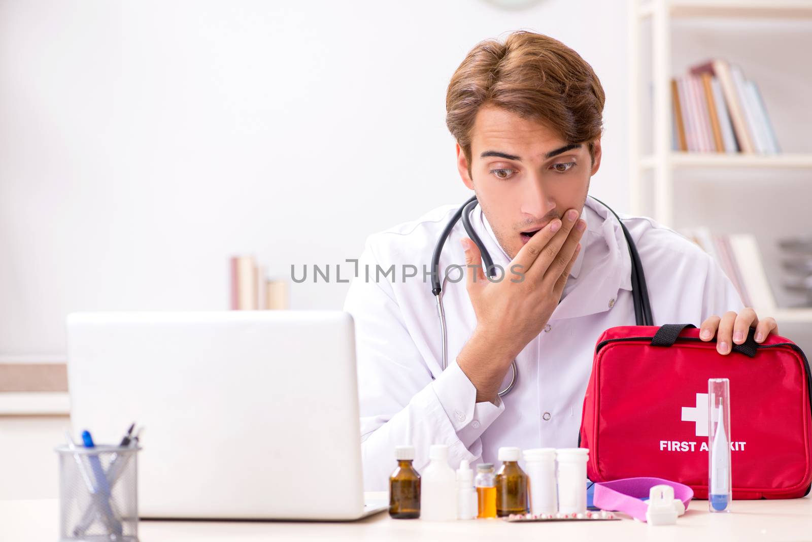 Young doctor with first aid kit in hospital