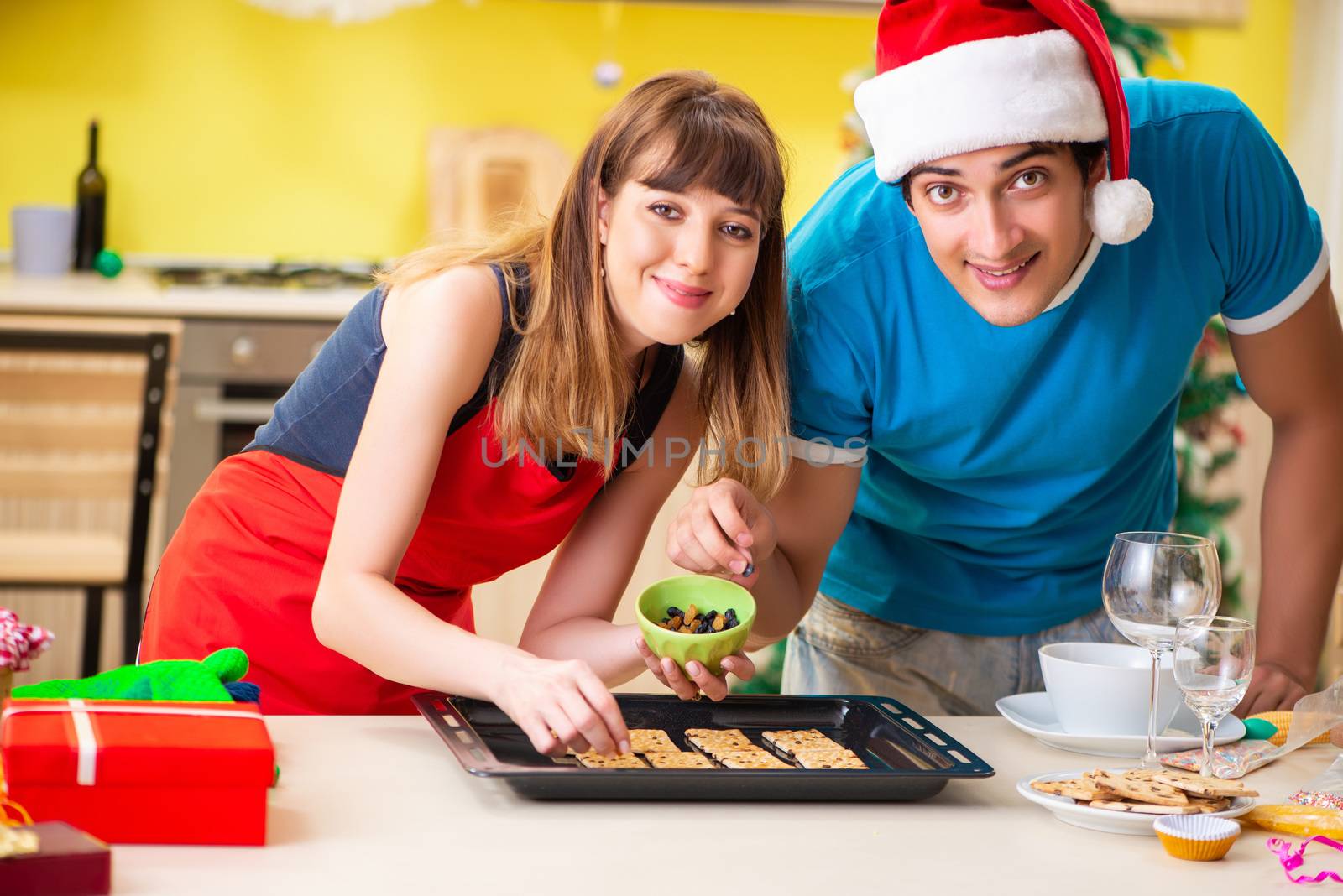 Young couple celebrating Christmas in kitchen 