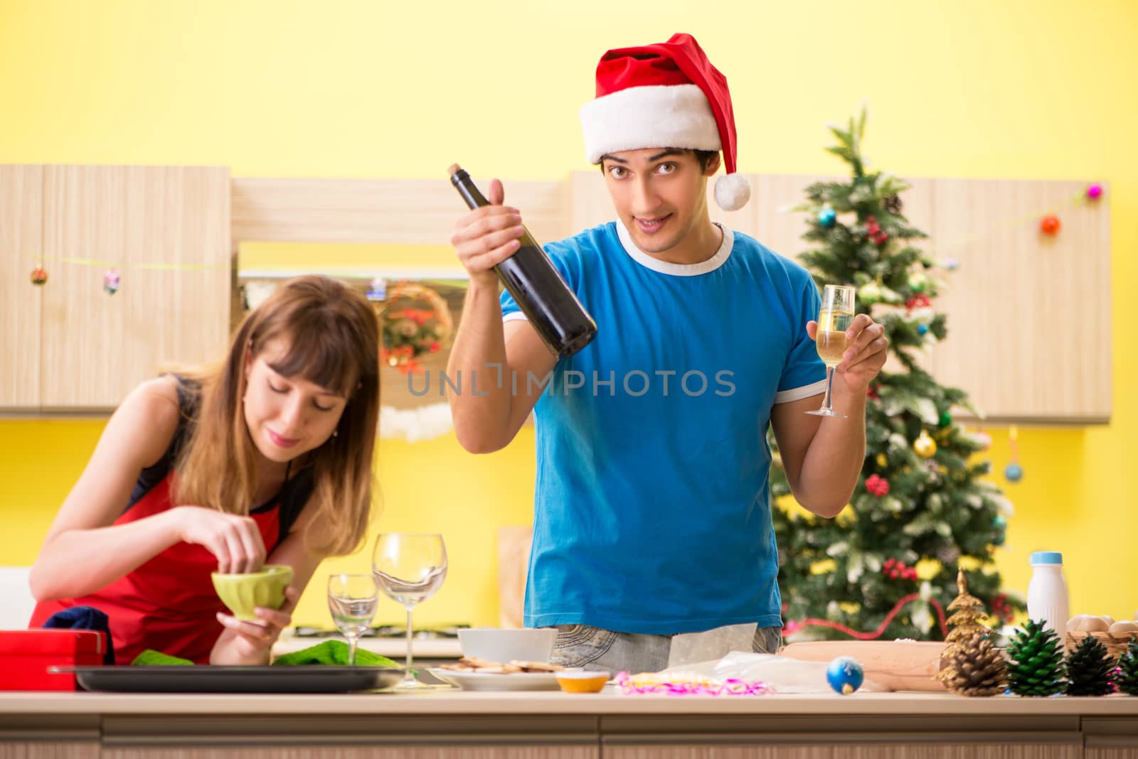 Young couple celebrating Christmas in kitchen 