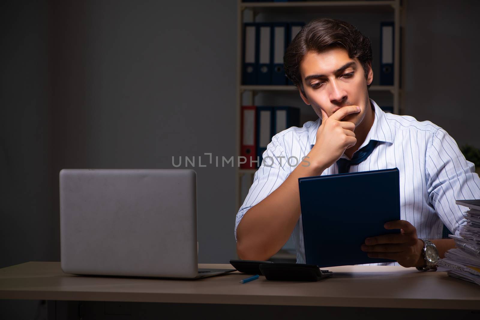 Young financial manager working late at night in office 