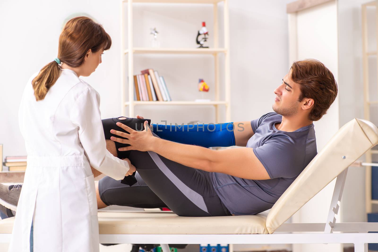 Young male patient visiting female doctor traumatologist 