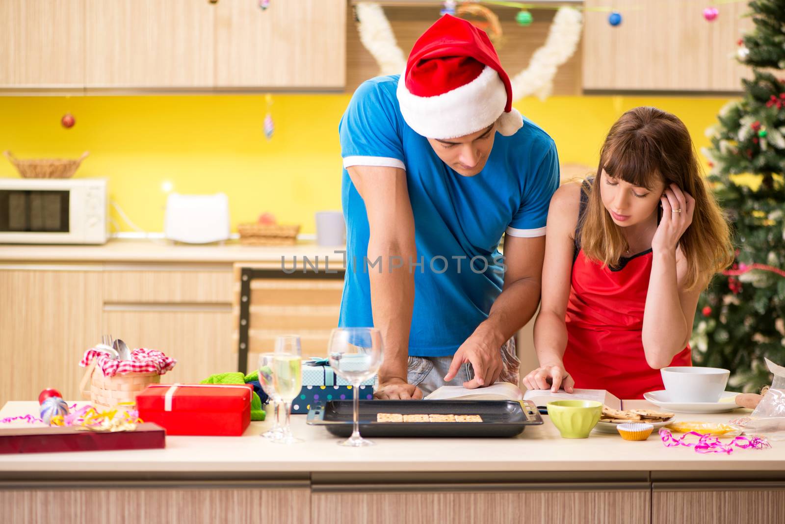 Young couple celebrating Christmas in kitchen 