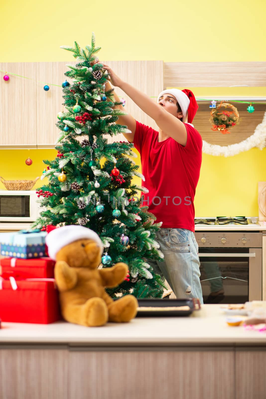 Young man celebrating Christmas in kitchen  by Elnur