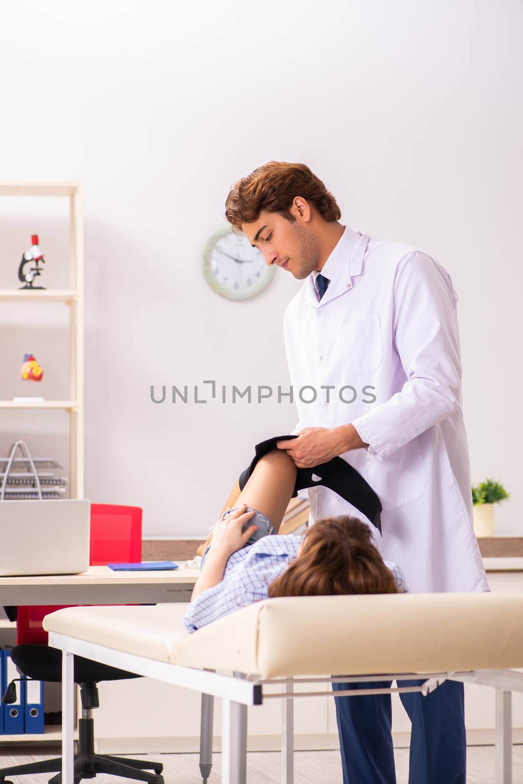 Young female patient visiting male doctor traumatologist  by Elnur