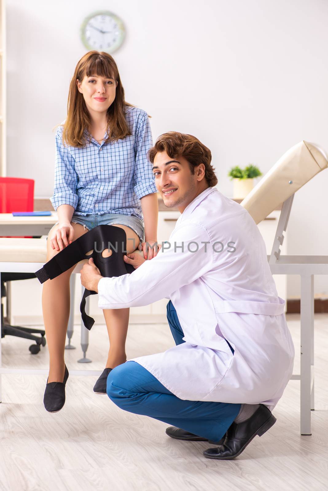 Young female patient visiting male doctor traumatologist 