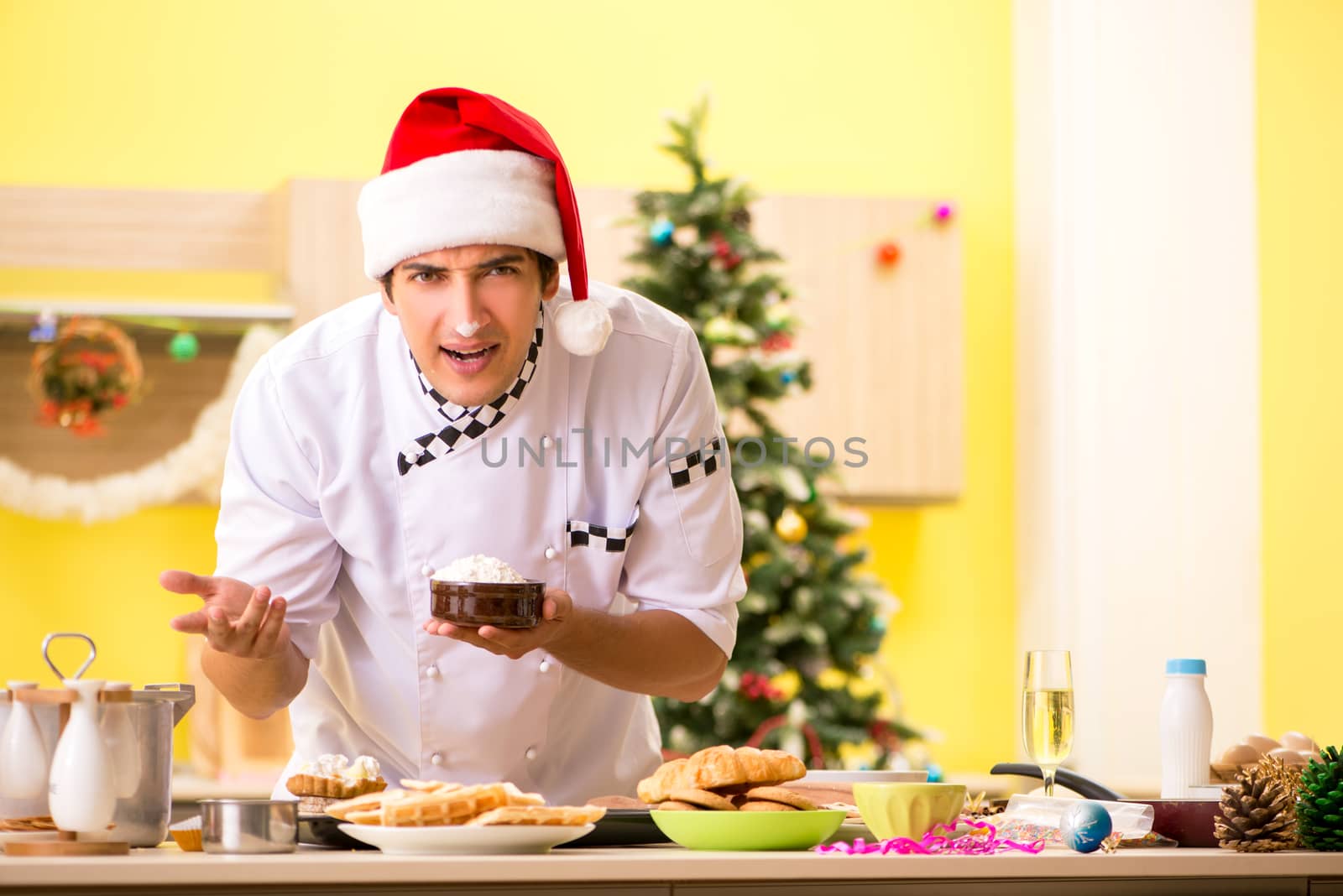 Young chef husband working in kitchen at Christmas eve 