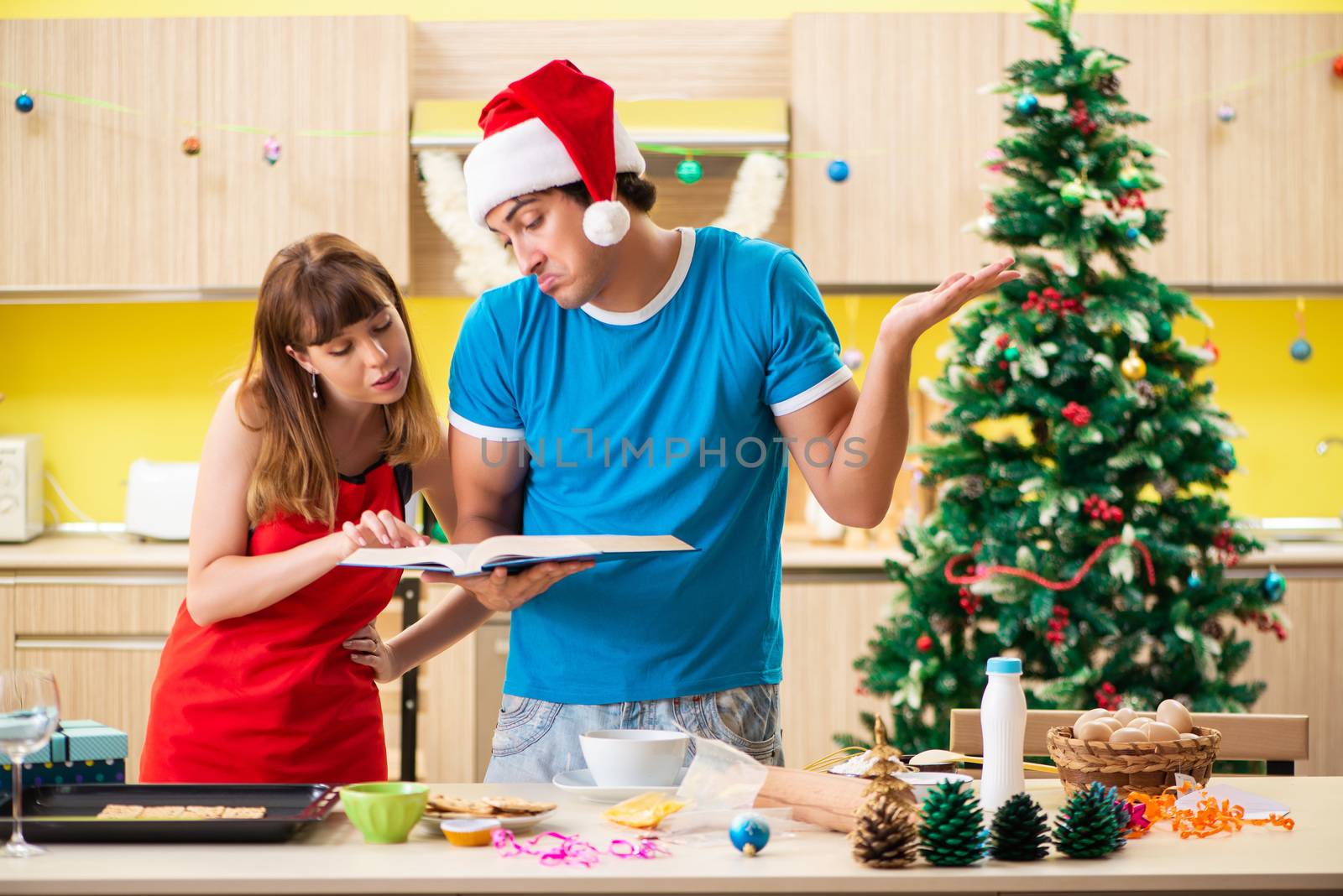 Young couple celebrating Christmas in kitchen 