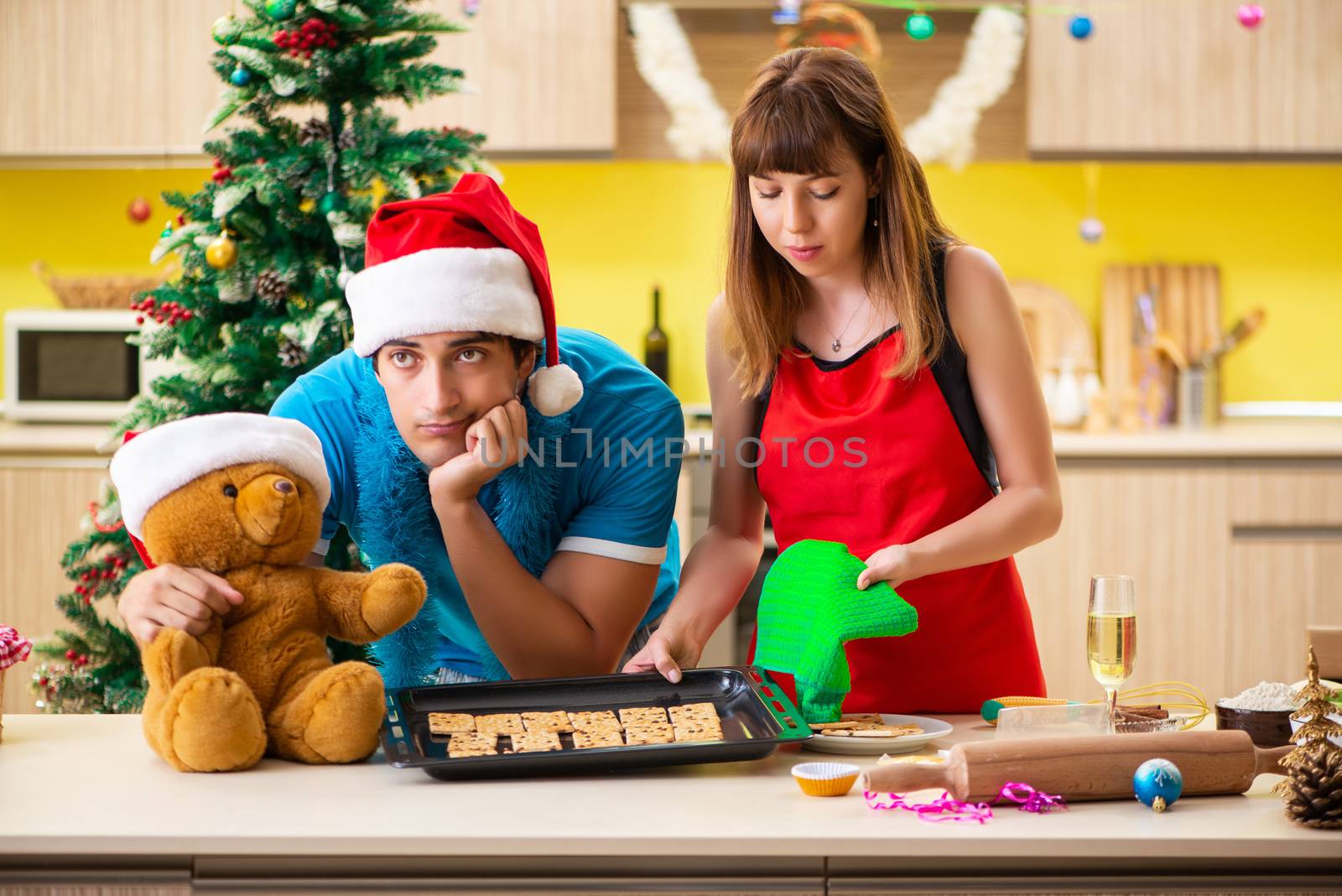 Young couple celebrating Christmas in kitchen 