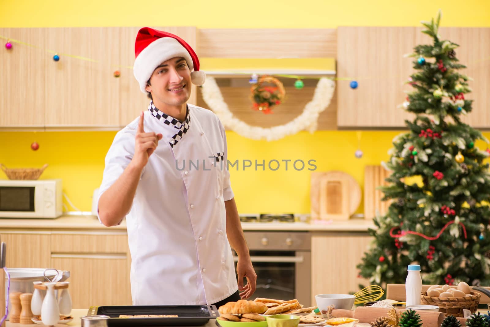 Young chef husband working in kitchen at Christmas eve 