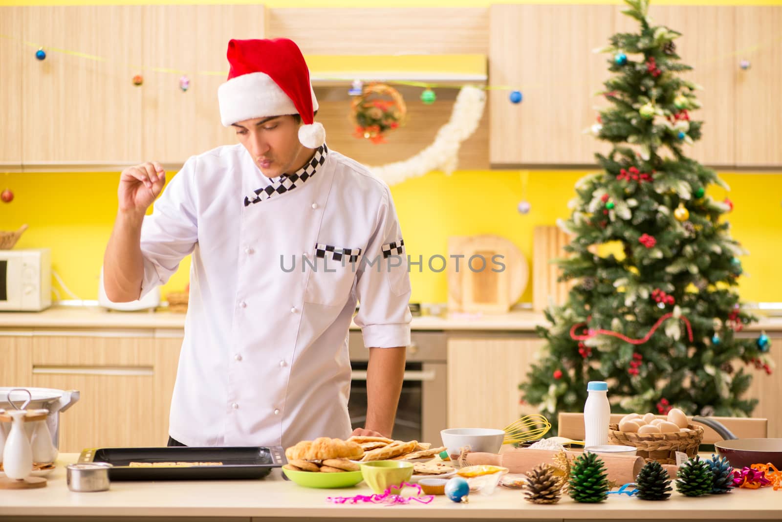 Young chef husband working in kitchen at Christmas eve 