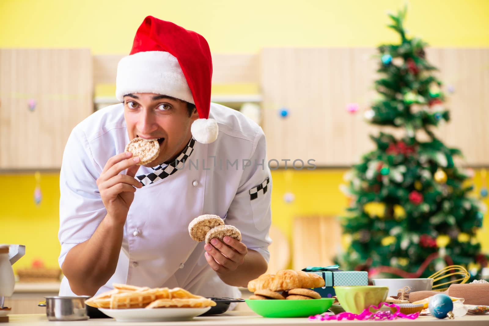 Young chef husband working in kitchen at Christmas eve 