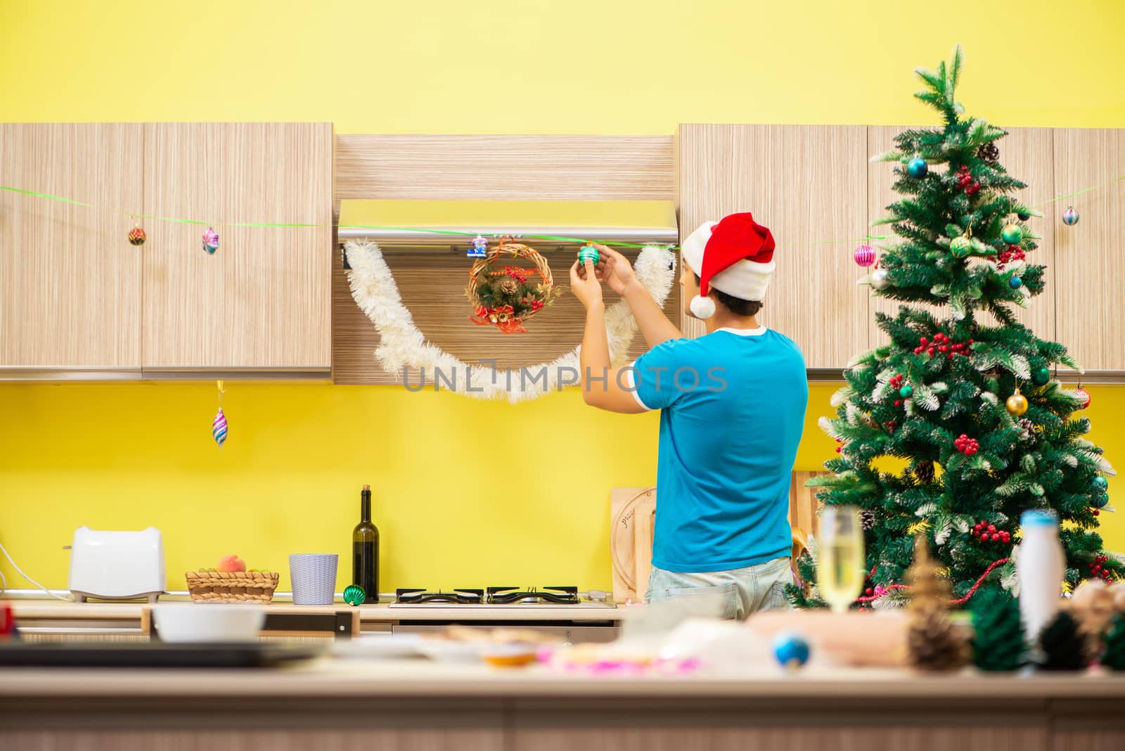 Young man celebrating Christmas in kitchen 