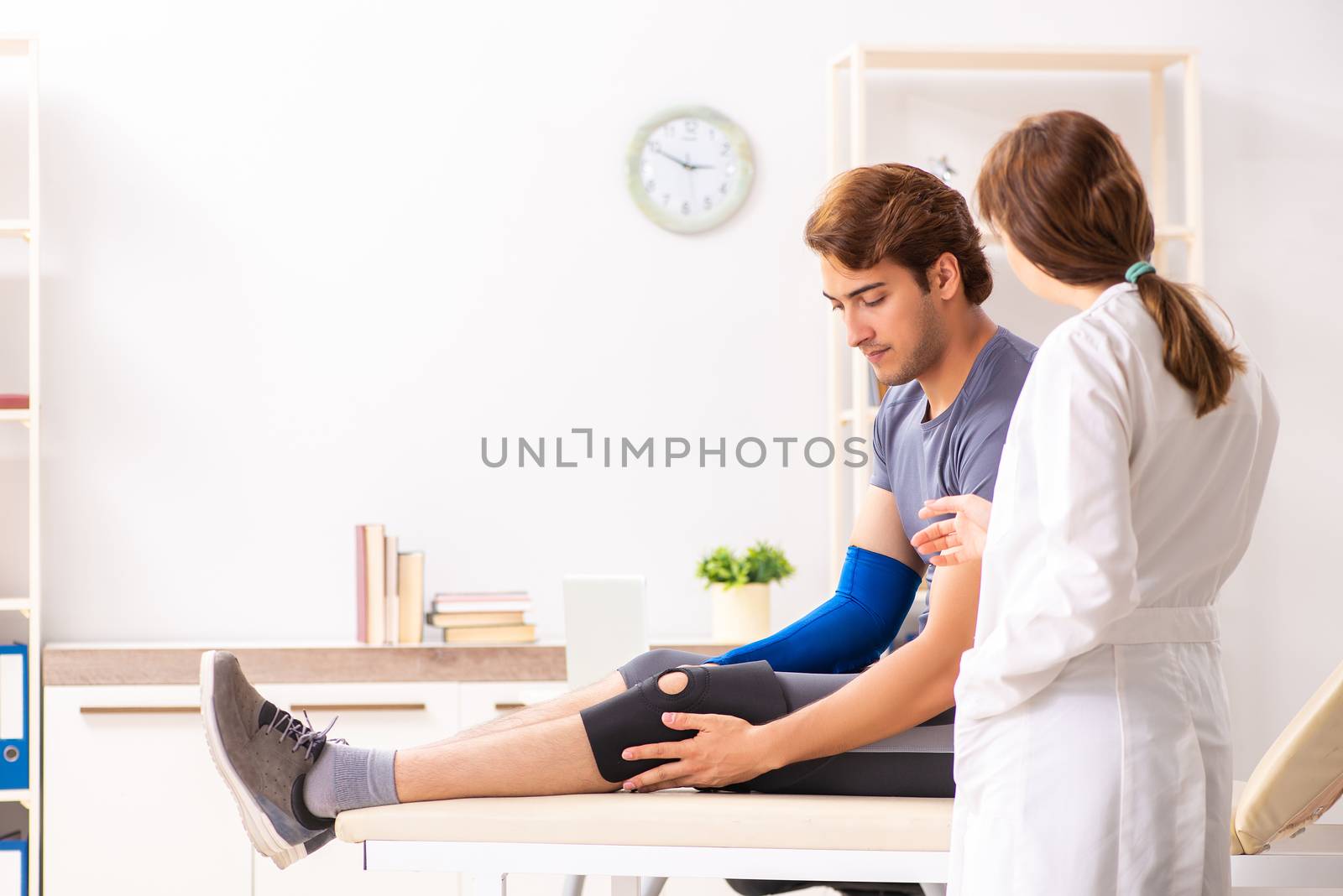 Young male patient visiting female doctor traumatologist 