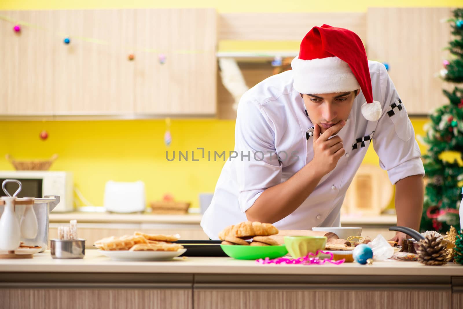 Young chef husband working in kitchen at Christmas eve 