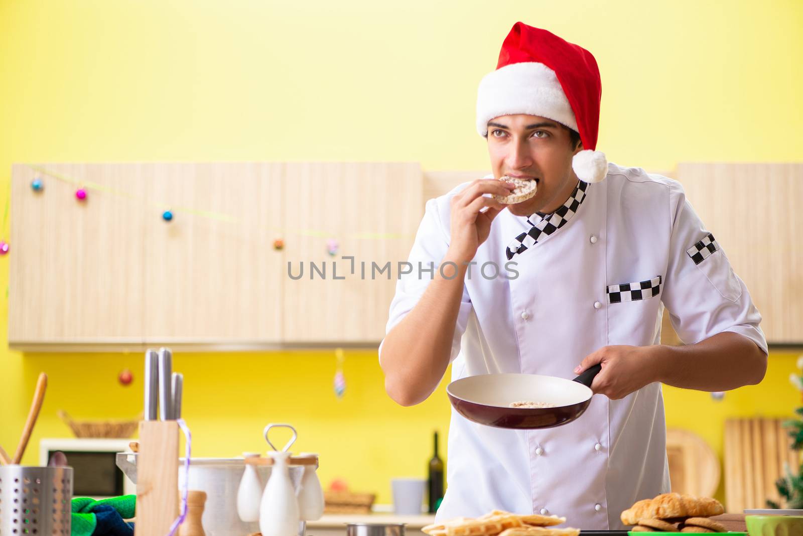Young chef husband working in kitchen at Christmas eve 