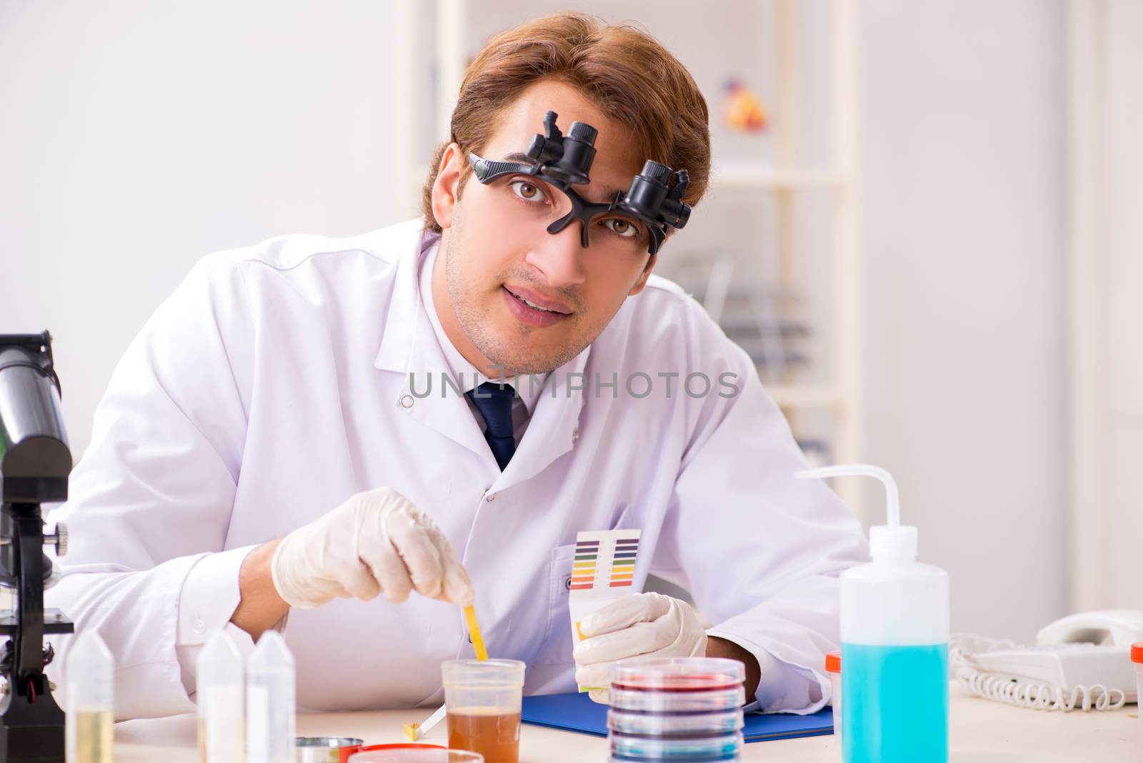 Chemist in the lab checking with ph strips