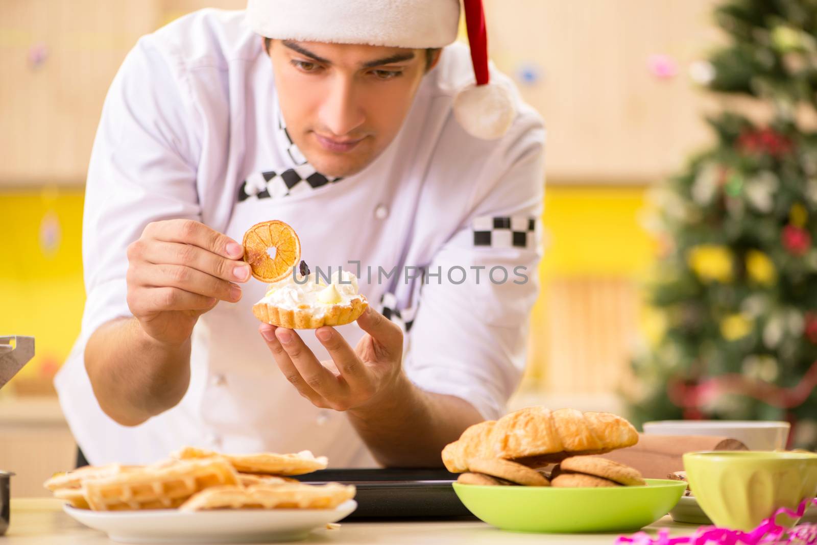 Young chef husband working in kitchen at Christmas eve 