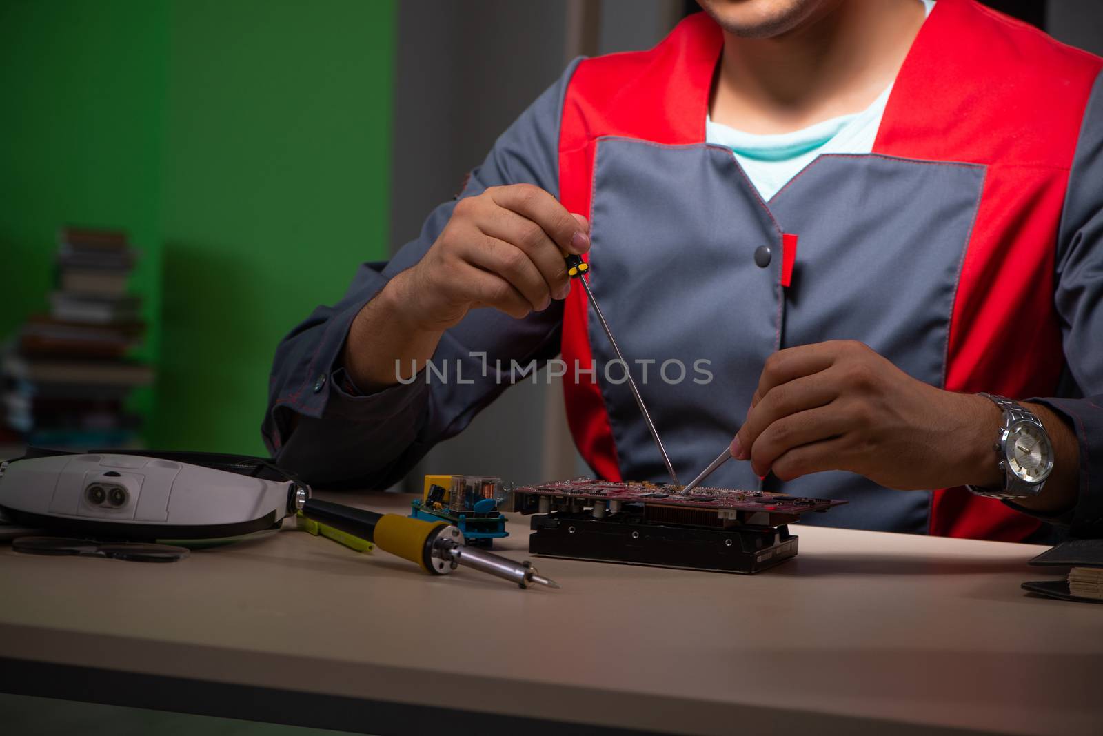 Young handsome repairman repairing computer 