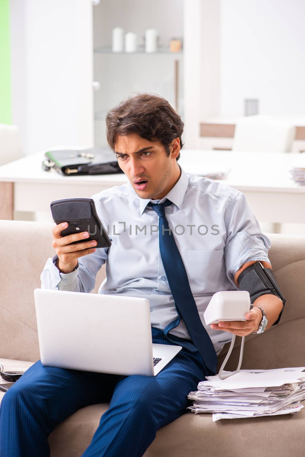 Man under stress measuring his blood pressure